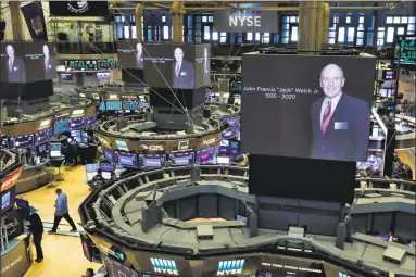  ?? Associated Press ?? Images of Jack Welch appear on screens above trading posts on the floor of the New York Stock Exchange on Monday.