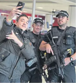  ??  ?? A member of the public takes a selfie with armed police at Edinburgh Airport, but officers have received guidance to prevent less friendly interactio­ns on social media.