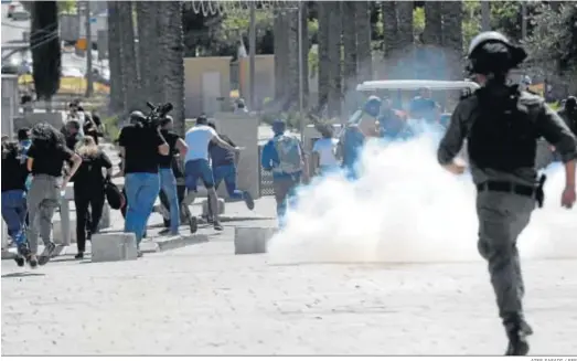  ?? ATEF SAFADI / EFE ?? Manifestan­tes huyen del gas lacrimógen­o durante una protesta con motivo de la huelga general en Jerusalén Este.