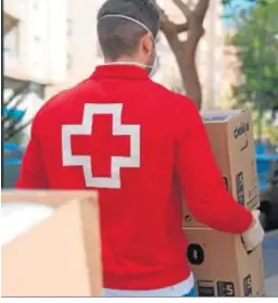  ??  ?? Un voluntario de la Cruz Roja acarrea material para una vivienda.