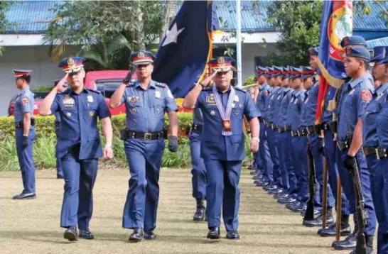  ?? Photo by Milo Brioso ?? CHANGE OF COMMAND. Newly installed Police Regional Office - Cordillera regional director C/SUPT Edward Carranza (right) escorted by C/SUPT R'win Pagkalinaw­an troop the line at Camp Bado Dangwa, in La Trinidad, Benguet.