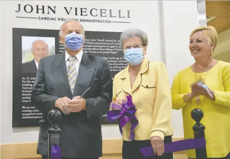  ?? KATHLEEN SAYLORS ?? John Viecelli, left, who came to Canada from Italy as a 17-year-old, cuts the ribbon with wife Lia, centre, and daughter Nancy Travenetti at Hôtel-dieu Grace Healthcare on Friday for new cardiac offices named for him for his second $100,000 donation to the hospital.