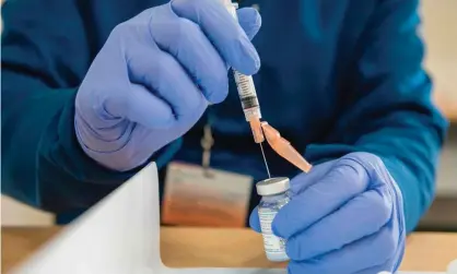  ?? Photograph: Joseph Prezioso/AFP/Getty Images ?? A pharmacist fills syringes with a Covid-19 vaccine.