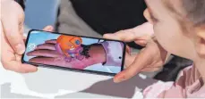  ?? FOTO: DANIEL KARMANN/DPA ?? Über die Kamera eines Mobiltelef­ons wird das Klebetatto­o Paw Patrol AR Tattoos & Stickers in Augmented Reality-Technik sichtbar.