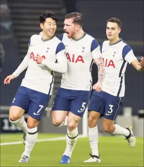  ?? Paul Childs / Associated Press ?? Tottenham’s Sergio Reguilon, right, and Pierre-Emile Hojbjerg, center, celebrate with Son Heung-min, left, who scored his side’s first goal against Arsenal on Sunday.