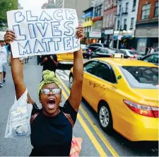  ??  ?? In piazza Un’attivista col cartello «Black Lives Matter», il movimento per la difesa degli afroameric­ani