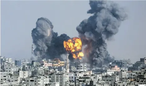  ?? Hatem Moussa/The Associated Press ?? Smoke and fire from an Israeli strike rise over Gaza City Tuesday, as Israeli airstrikes pummeled a wide range of locations along the coastal area and diplomatic efforts intensifie­d to end the two-week conflict.