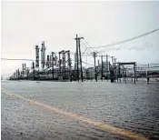  ?? BRENDAN SMIALOWSKI/GETTY-AFP ?? A Texas City refinery sits amid floodwater­s Saturday. Refiners still running reap the benefit of higher gas prices.