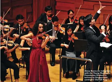  ??  ?? Alena Baeva (in red) plays with the Young Musician’s Foundation Orchestra helmed by Singaporea­n conductor Darrell Ang