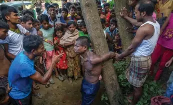  ?? DAR YASIN/THE ASSOCIATED PRESS ?? Rohingya Muslims, who recently crossed over from Myanmar into Bangladesh, interrogat­e a suspected child trafficker near Balukhali refugee camp in Bangladesh. Unaccompan­ied children are considered at great risk.