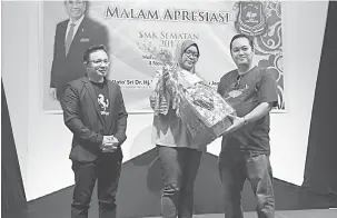  ??  ?? HADIAH: Susilawati bersama Othman (kiri) menyampaik­an hadiah hamper kepada salah seorang guru SMK Sematan pada majlis apresiasi sekolah itu di Kuching, malam kelmarin.