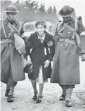  ?? SEATTLE TIMES FILE PHOTO ?? In this 1942 photo, soldiers lead a woman to an internment camp.