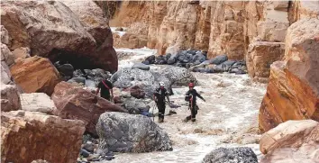  ?? Reuters ?? Civil Defence members look for survivors after rain storms unleashed flash floods near the Dead Sea yesterday. Several people are still feared missing in the Jordan Valley.