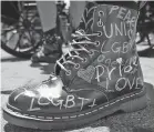  ??  ?? A person wears Pride-themed boots while awaiting the start of the queer liberation march in New York.