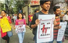  ?? AP ?? University students display slogans as they walk in a protest rally in Kolkata yesterday.