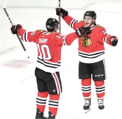  ??  ?? Patrick Sharp ( left) celebrates with Alex DeBrincat after tying the game at 3 in the third period Monday night.