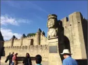  ??  ?? A reproducti­on bust of the mythical Lady Carcas greets tourists at the gate of Carcassonn­e’s medieval Cite.