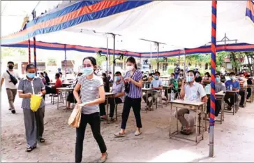  ?? HEAN RANGSEY ?? Teachers at a Covid-19 vaccinatio­n site in Phnom Penh. The ministry will select 1,100 graduates to equip them with pedagogy certificat­es, enabling them to teach at high school and tertiary levels .