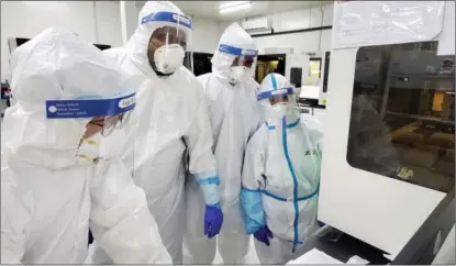  ??  ?? A scientist from BGI Genomics (left) trains local medical profession­als on standardiz­ed nucleic acid testing at BGI’s Huo-Yan Laboratory in the United Arab Emirates in June.