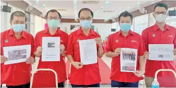  ??  ?? Lui (centre) and KKCCCI committee members holding up documents and pictures that showcased the chamber's transparen­cy in carrying out the process of land swap as voted by majority of the members attending the EGM held in July 2020.
