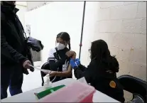  ?? GREGORY BULL — THE ASSOCIATED PRESS ?? Leslie Flores, center, of Tijuana, Mexico, looks over documents with her father, Jack Flores, left, before receiving a vaccinatio­n shot against the coronaviru­s outside of the Mexican Consulate building, Thursday, Nov. 18, 2021, in San Diego.