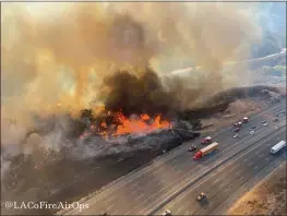  ?? LOS ANGELES COUNTY FIRE AIR OPERATIONS VIA AP ?? Air Operations traffic passes the Route fire, a brush wildfire off Interstate 5north of Castaic on Saturday.