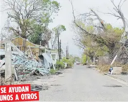  ??  ?? SE AYUDAN UNOS A OTROS
La mayoría de las casas en este sector, construida­s en madera, resultaron con daños severos por el ciclón.