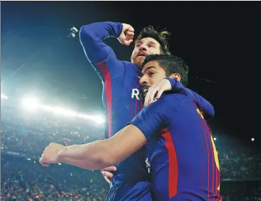  ?? SERGIO PEREZ / REUTERS ?? Barcelona's Lionel Messi is hoisted by teammate Luis Suarez after scoring a brilliant goal in Sunday’s 2-2 draw with Real Madrid at
Camp Nou in Barcelona.