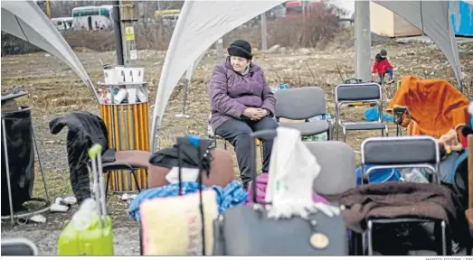  ?? MARTIN DIVISEK / EFE ?? Una mujer procedente de Ucrania espera sentada tras llegar a Vysne Nemecke tras cruzar la frontera con Eslovaquia.