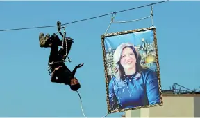  ?? AP ?? A Hamas security officer pulls a picture of slain Palestinia­n-American journalist Shireen Abu Akleh during a presentati­on at a graduation ceremony for Al-Rebat College’s Police Academy, in Khan Younis, southern Gaza Strip.