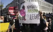  ?? ESTEBAN FELIX AP ?? A demonstrat­or holds a sign that says ‘No person is illegal’ during a march Oct. 3 in favor of migrants’ rights in Santiago, Chile.