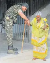  ?? PTI PHOTO ?? A CRPF personnel helps an aged woman at a polling station in West Bengal’s Maheshtala on Monday.