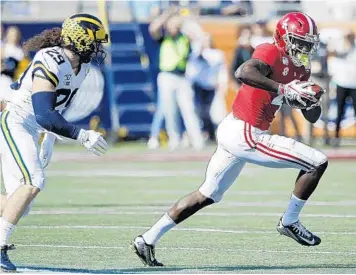  ?? JOE ROBBINS/GETTY ?? Alabama receiver Jerry Jeudy runs after catching a pass in front of Michigan’s Jordan Glasgow during the Citrus Bowl at Camping World Stadium on Wednesday. Jeudy had 204 yards receiving and was named the game MVP.