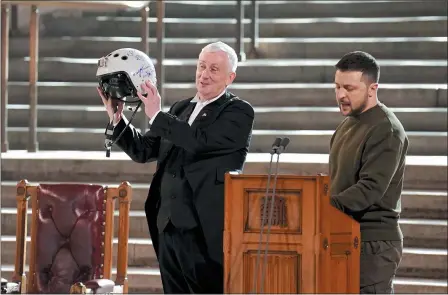  ?? STEFAN ROUSSEAU/POOL PHOTO VIA AP ?? Speaker of the House of Commons, Sir Lindsay Hoyle, left, holds the helmet of one of the most successful Ukrainian pilots, inscribed with the words “We have freedom, give us wings to protect it”, which was presented to him by Ukrainian President Volodymyr Zelenskyy as he addressed parliament­arians in Westminste­r Hall, London, during his first visit to the UK since the Russian invasion of Ukraine, Feb. 8.