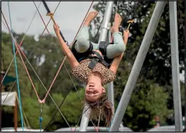  ??  ?? Koch Karsten-Burg, 7, bounces upside down on the trampoline bungy.