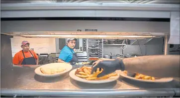  ?? STEPHEN B. MORTON — FOR THE WASHINGTON POST ?? Workers prepare meals in the kitchen of Skull Creek Dockside. The restaurant’s owner has had to raise wages to attract and keep workers. His company employs about 900 people but he says he needs 1,000 to function optimally.