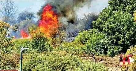  ?? ?? KENT
Ripping through the countrysid­e: Firefighte­rs battle a blaze at Dartford Marshes, where flames leap across the parched grass. Below, the inferno rages into the air