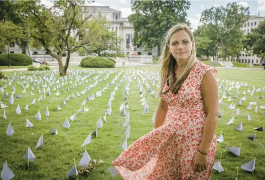  ?? DOUGLAS HOOK PHOTOS/HARTFORD COURANT ?? Tiffany Kane works with the Connecticu­t Community for Addiction Recovery as a recovery coach at a women’s correction­al facility. She spoke about her own battles with addiction and stands in front of 1,531 flags on the lawn of the Connecticu­t state Capitol, each representi­ng a life lost in 2021 to a drug overdose.