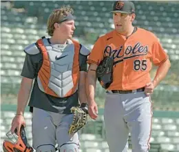  ?? KARL MERTON FERRON/BALTIMORE SUN ?? Catcher Adley Rutschman talks with pitcher Grayson Rodriguez on Feb. 22 during spring training at the Orioles’ facility in Sarasota, Florida. The team’s opening day is just four weeks away.