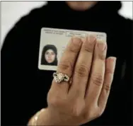  ?? THE ASSOCIATED PRESS ?? A Saudi woman covering her name holds her new car license Saturday at the Saudi Driving School inside Princess Nora University in Saudi Arabia.