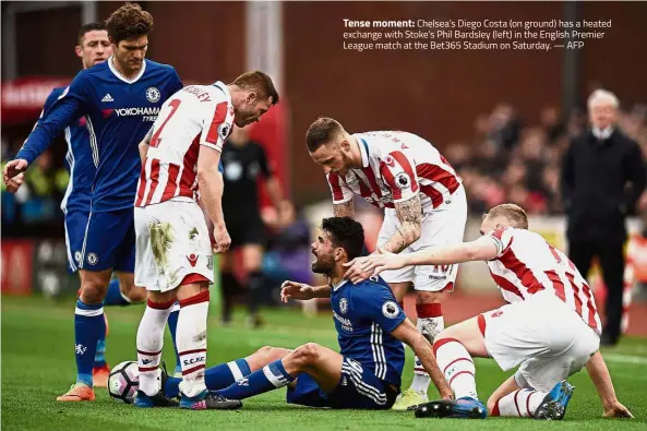  ?? — AFP ?? Tense moment: Chelsea’s Diego Costa (on ground) has a heated exchange with Stoke’s Phil Bardsley (left) in the English Premier League match at the Bet365 Stadium on Saturday.
