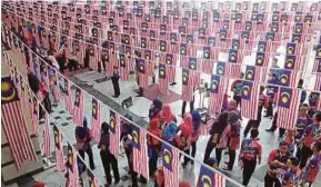  ?? FILE PIC ?? National Civics Bureau employees decorating the agency’s headquarte­rs for its National Day event in Putrajaya last year.