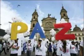  ?? JENNIFER ALARCON — THE ASSOCIATED PRESS FILE ?? People hold up letters that form the Spanish word for “Peace” during a gathering at Bolivar Square, in Bogota, Colombia. Pope Francis’ efforts to consolidat­e Colombia’s peace process with a five-day visit produced a result even before the trip began: a...