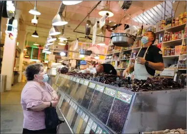  ?? (AP/Marcio Jose Sanchez) ?? A customer (left) is tended to at the Grand Central Market last week, in Los Angeles.