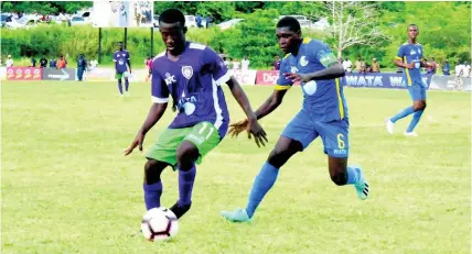  ??  ?? William Knibb Memorial High School’s Deano Thomas (left) is tracked by Cedric Titus High School’s Javel Green in their ISSA/WATA DaCosta Cup Group C encounter at William Knibb on September 17.