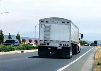  ?? ?? A semitruck travels eastbound on Ethanac Road as it passes a Welcome to Menifee sign, east of Goetz Road in Menifee on Thursday.