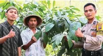  ?? AIPDA SURATNO FOR JAWA POS ?? SINERGI: Aipda Suranto bersama warga Purwosari menunjukka­n tanaman kopi yang jadi produk andalan desa tersebut.