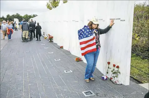  ??  ?? Chrissy Bortz of Latrobe touches the names on the Flight 93 National Memorial after the 17th anniversar­y observance of 9/11 on Tuesday in Stonycreek. Ms. Bortz visited the memorial to pay respects to the victims.