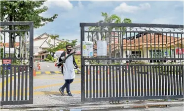  ?? — Bernama ?? Keeping clean: A worker disinfecti­ng the entrance to SK Presint 8 (1) in Putrajaya after the school was instructed to close for eight days from Oct 9-16.