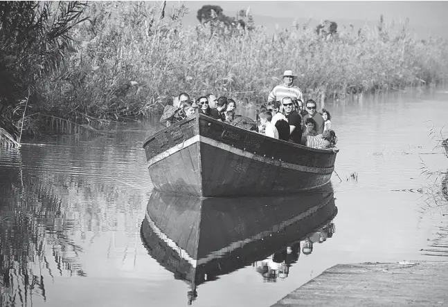  ?? Fotos: Ángel García ?? Mit Motor und Stochersta­nge: Bootsführe­r Juan Vilches schippert täglich Touristen über den See.